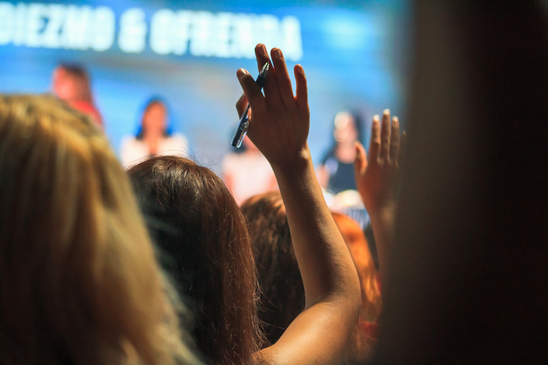 An audience engaging with people giving speeches on a stage